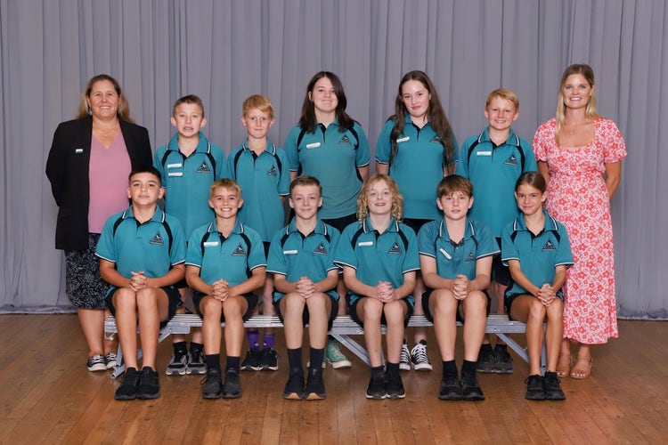 6 students in front row sitting and smiling with a teacher on either end standing ans smiling and 5 students in the back standing and smiling