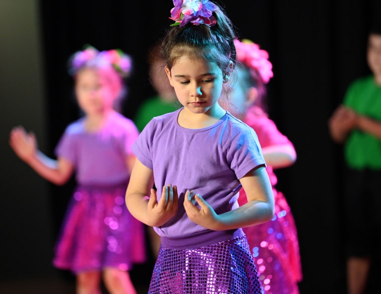 Student in purple dancing on stage
