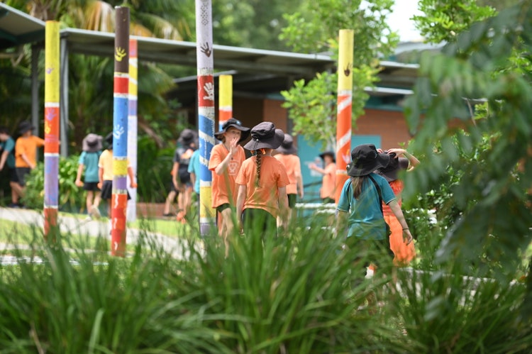 Shows students in the background dressed in orange